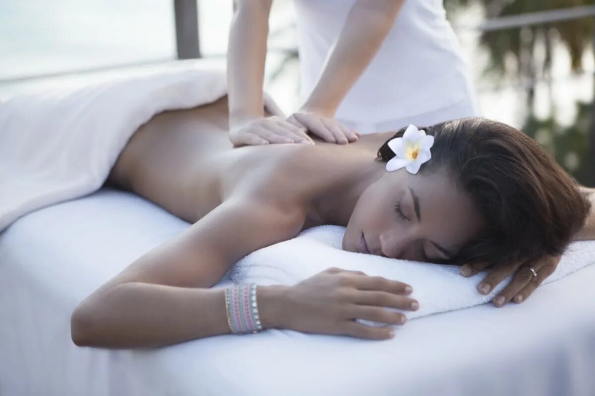 девушка брюнетка на массаже. массаж белой девушки. женщина лежит на массаже. спа. релакс массаж.