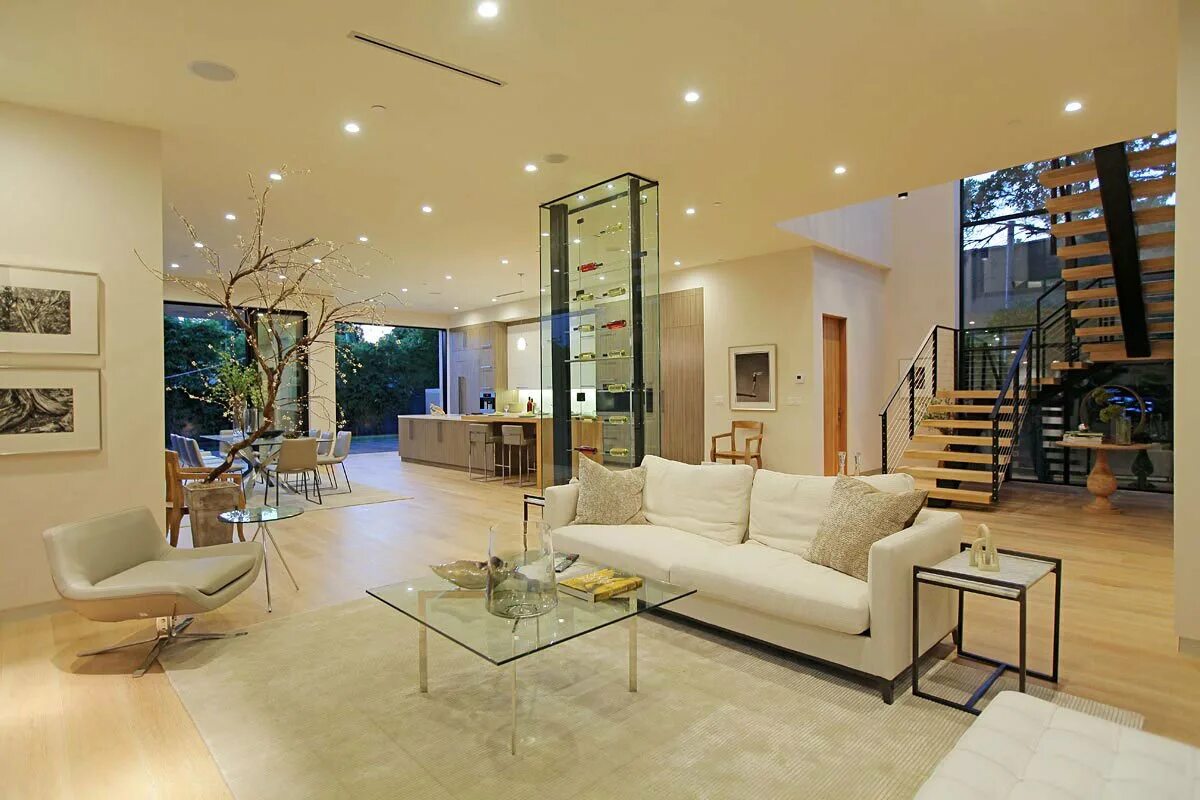 освещение гостиных частного дома. просторная гостиная в загородном доме. каминный зал в частном доме. камины в интерьере гостиной. современное освещение в гостиной.