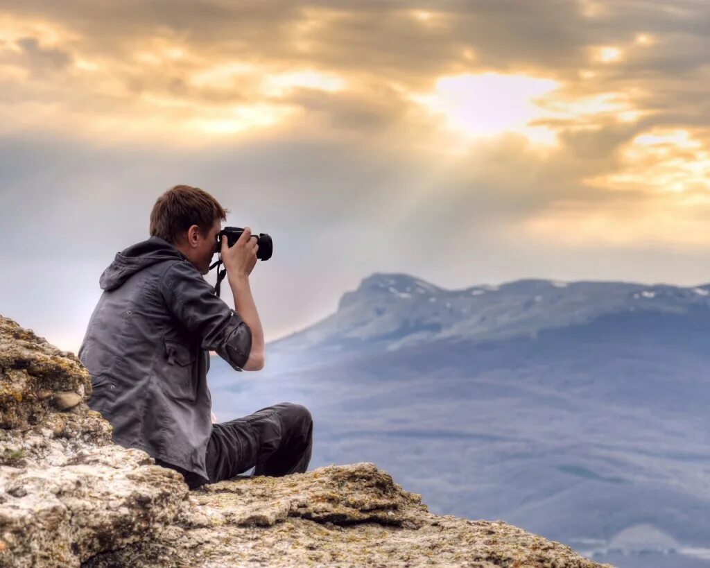 Лучшие хобби. Человек с фотоаппаратом. Фотограф фотографирует. Парень фотографирует. Путешественник с фотоаппаратом.