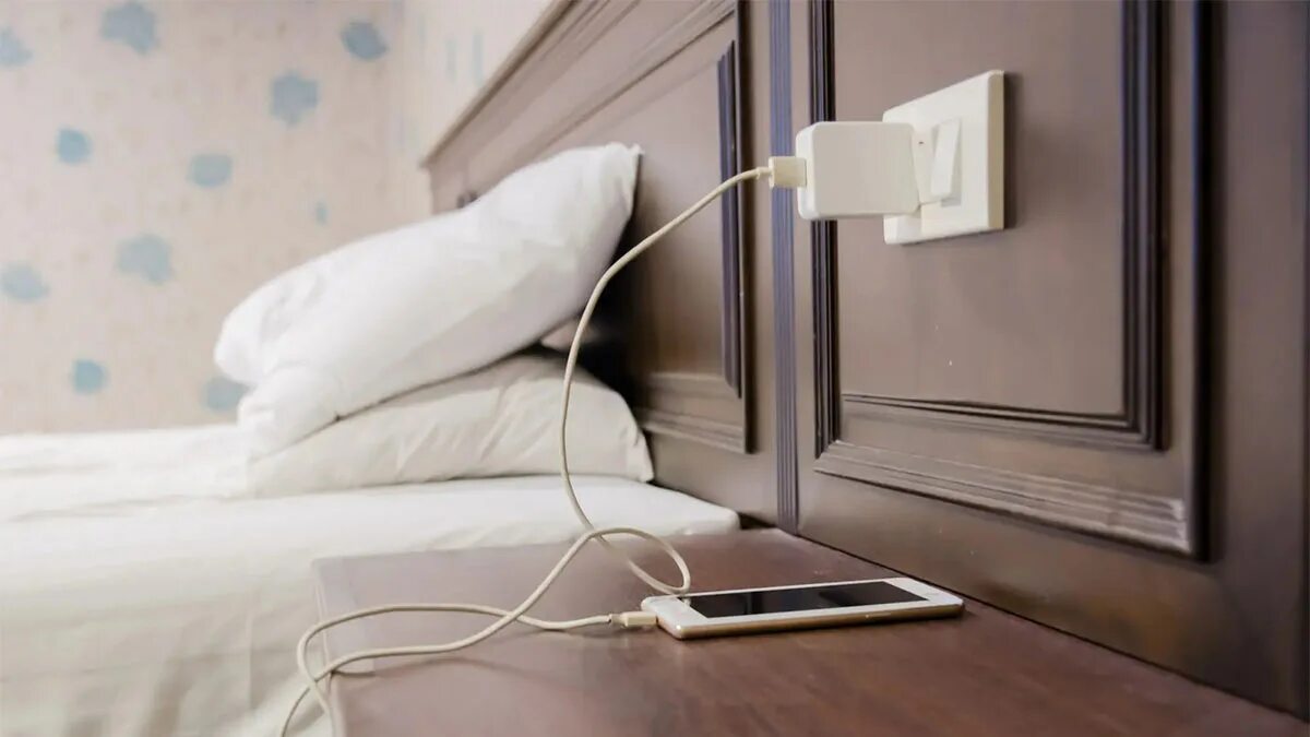 смартфон на зарядке ночью. смартфон в постели. можно ли поставить на зарядку на ночь. почему нельзя оставлять телефон на зарядке на ночь. опасная зарядка для.