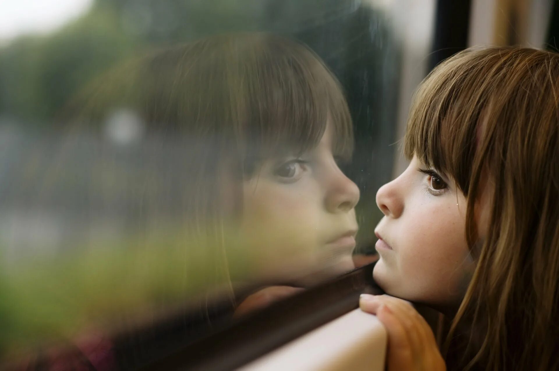 Она видит что ее маленькие. Грустный ребенок. Девочка грустит. Маленькая девочка у окна. Дети ждут.