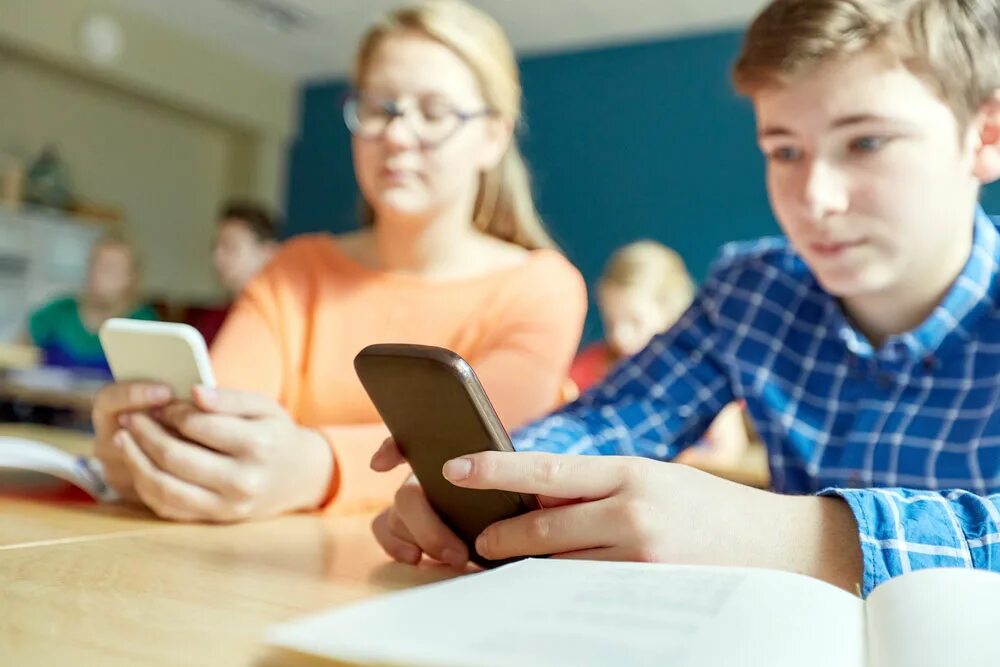 Как найти телефон в школе. Школьник с телефоном. подросток со смартфоном. старшеклассник с телефоном. подросток с телефоном в руках.