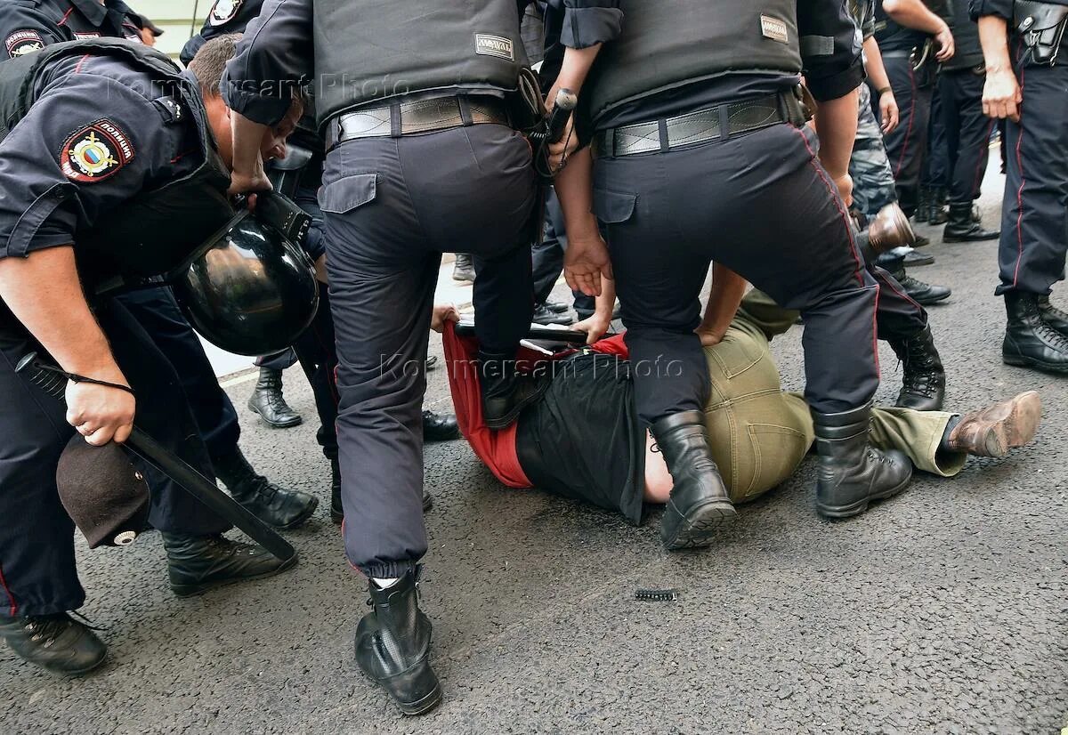 Полицейский избивает человека. Полицейские на митинге в москве. Девушки полицейские на митинге. Задержания на митинге в москве. Полицейские тащат человека.