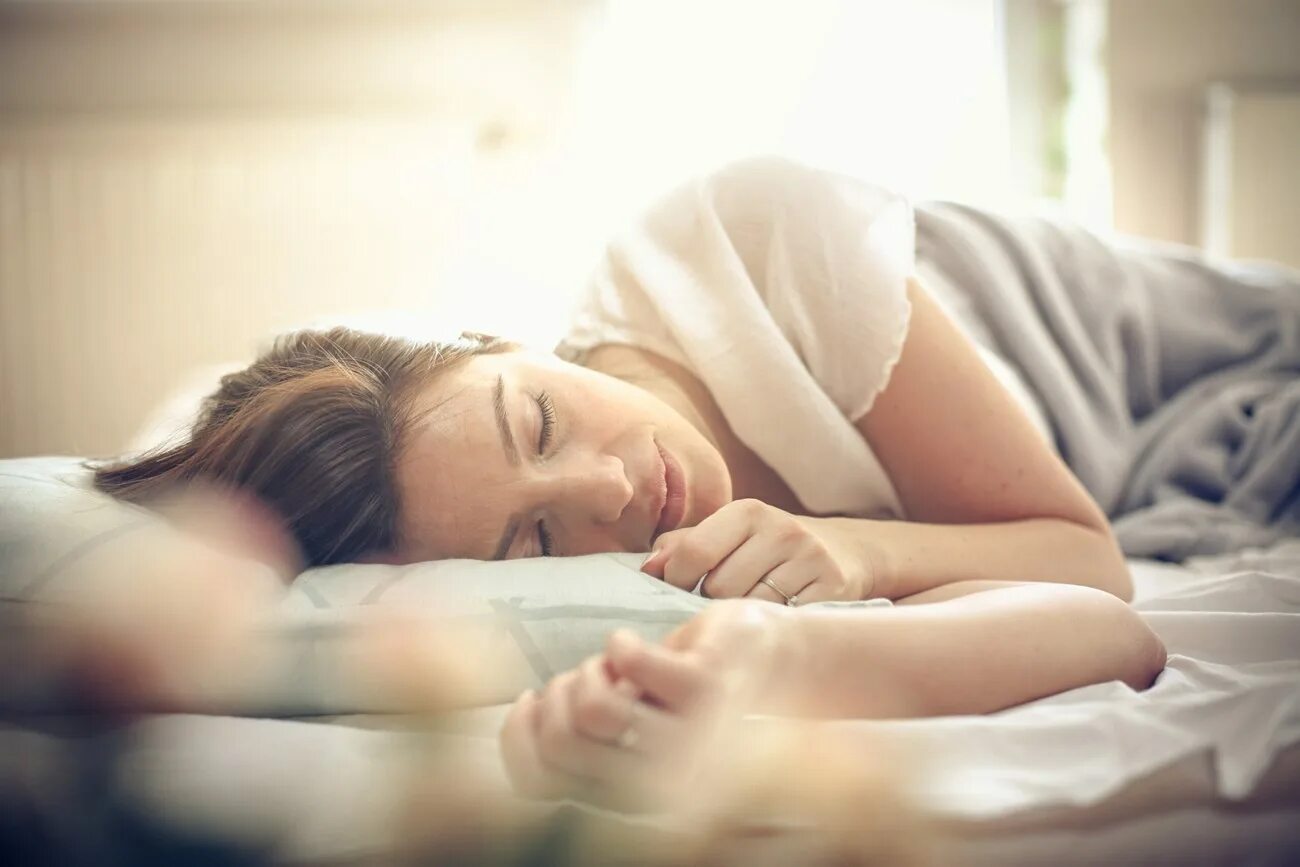 Sleep habits. Здоровый сон. Женщина засыпает. Девушка улыбается во сне.