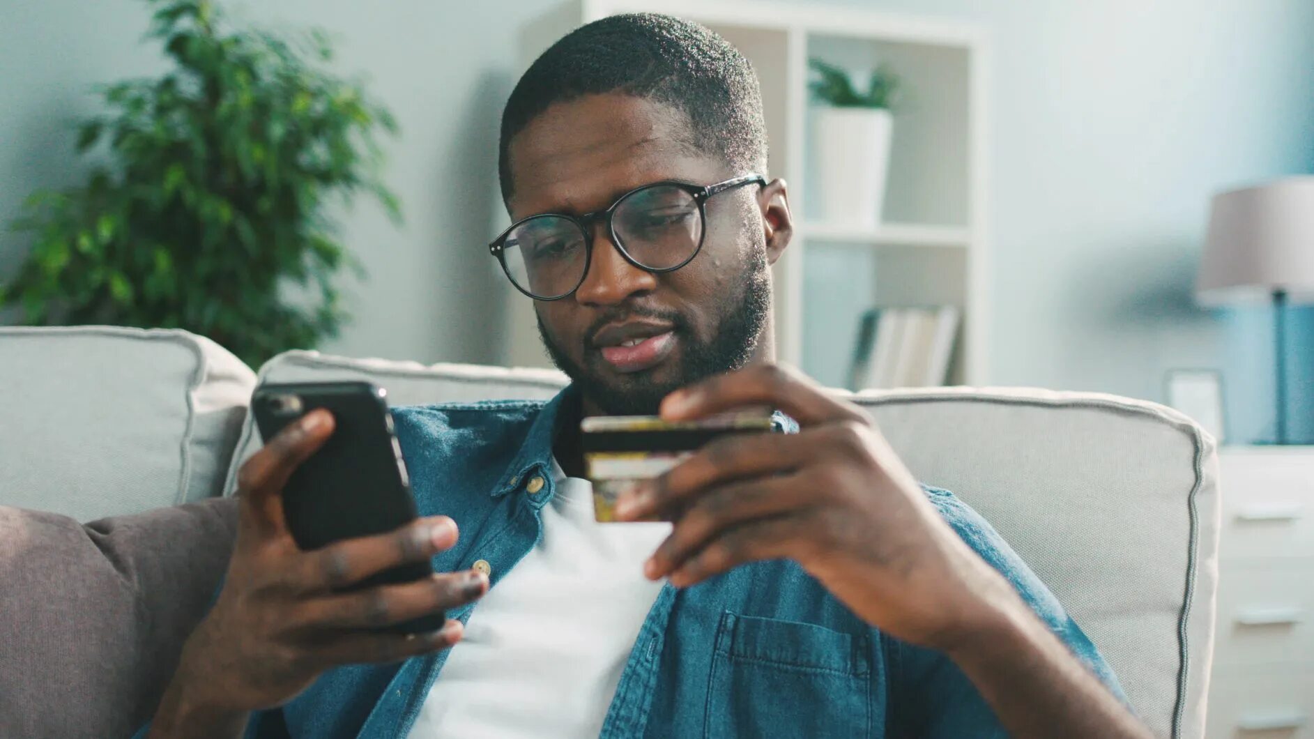 Can i use your mobile phone. African man holding a phone. happy black man with phone. black person with a phone smiling. black man shopping.