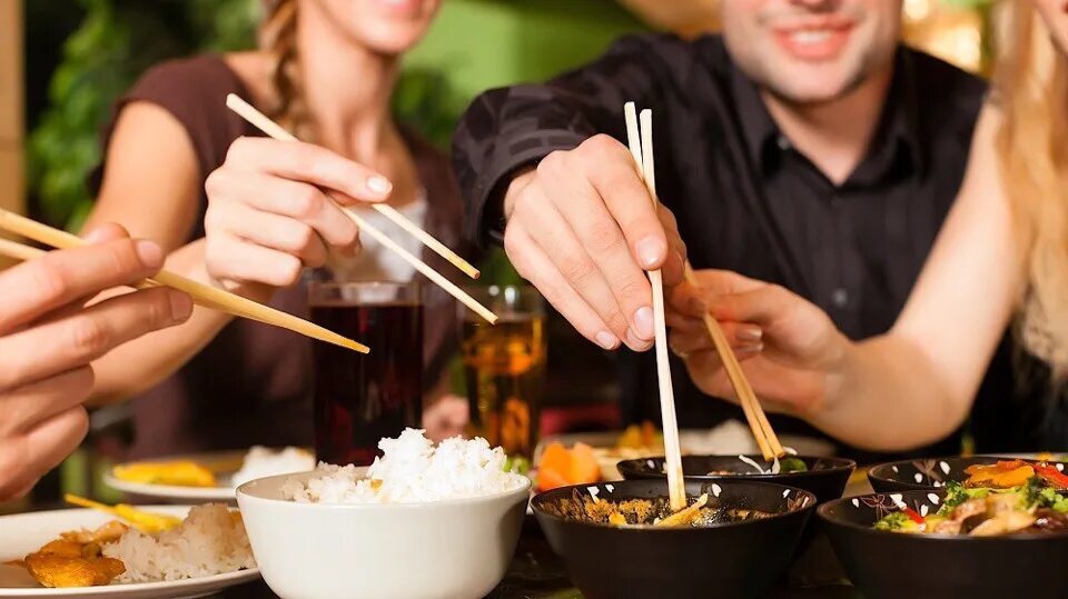 Пробуем разную еду. Еда в ресторане. Люди едят роллы. Японская кухня. Кушать в ресторане.