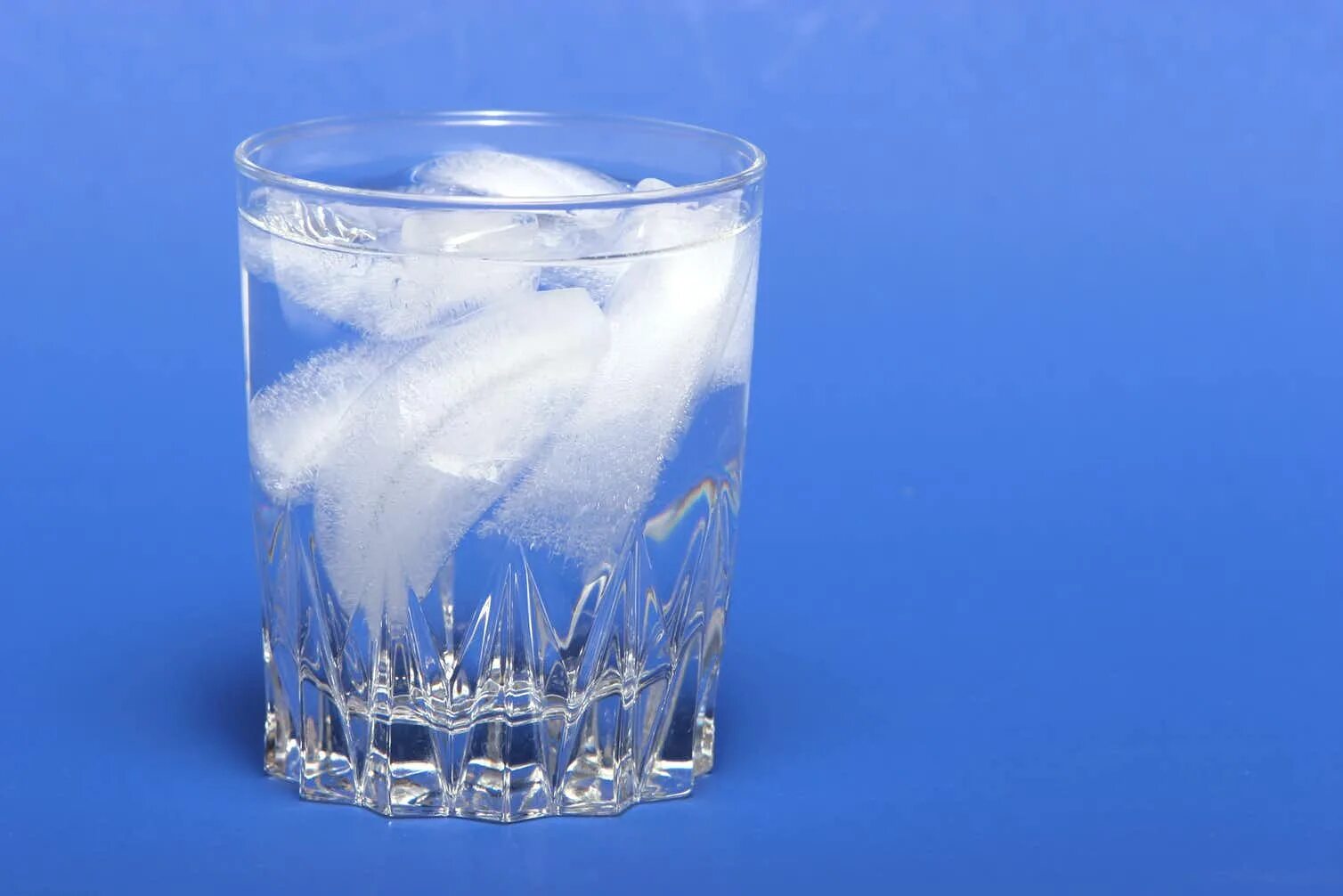 Замерзание воды. Стакан воды со льдом. Превращение воды в лед. Вода превращается в лед. Лед плавает в стакане.