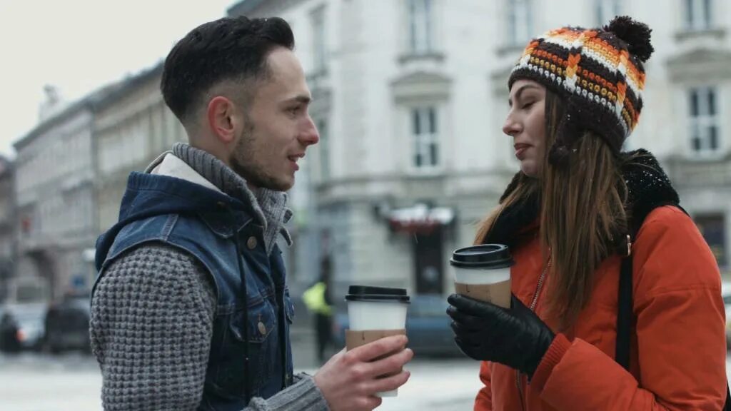 People Drink Coffee in Winter on the Street. Meet couple