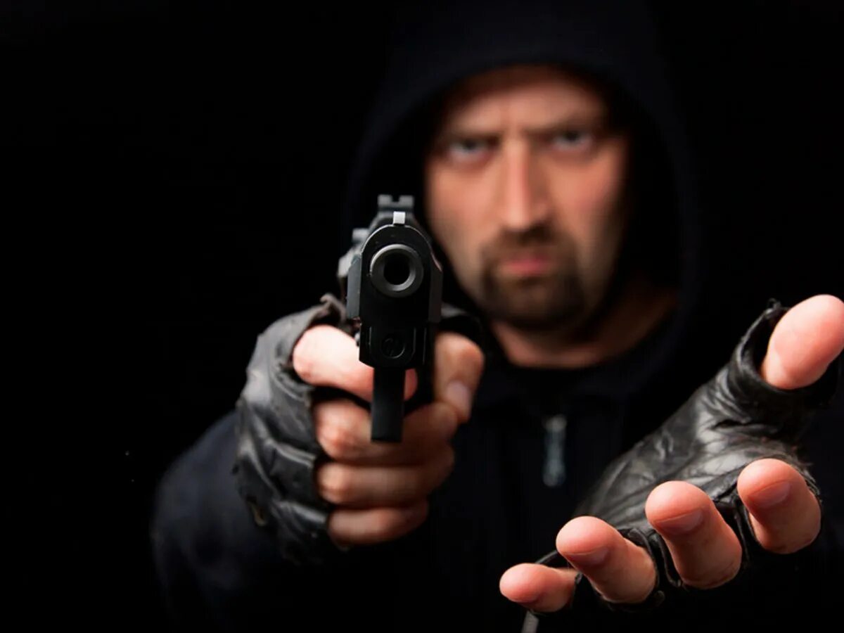 Бандит с пистолетом. Человек с пистолетом. Мужик с пистолетом. Угрожает пистолетом.