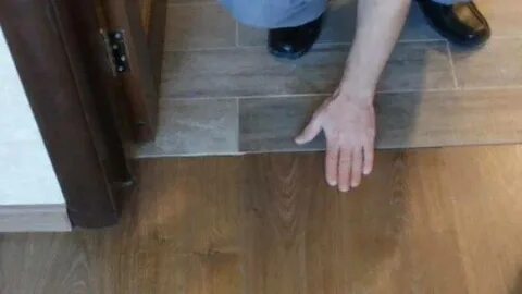 Стык напольных покрытий под дверью