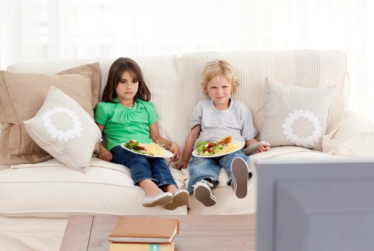 Дети перед телевизором. Диван для детей. Диван малыш. Дети едят на диване. Ребенок сидит на диване.