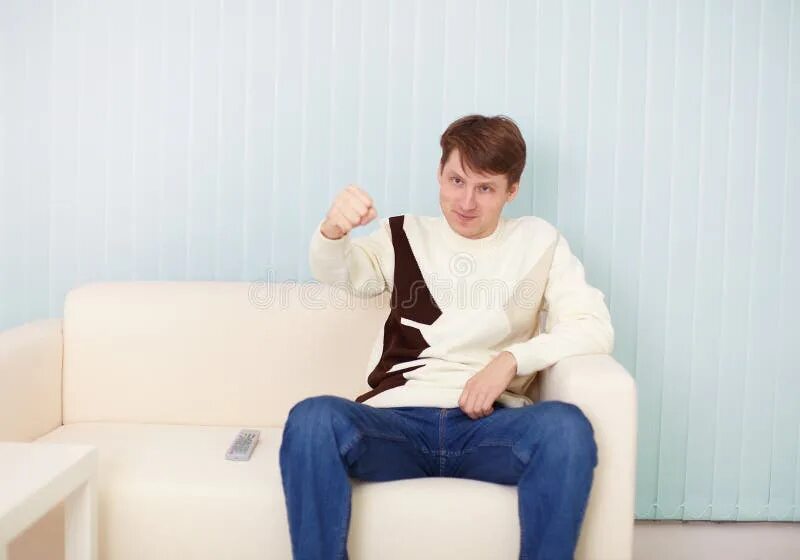 Ничем сижу на диване. Человек сидит на диване. парень сидит на диване. сидячий человек на диване. парень сидит на кушетке.