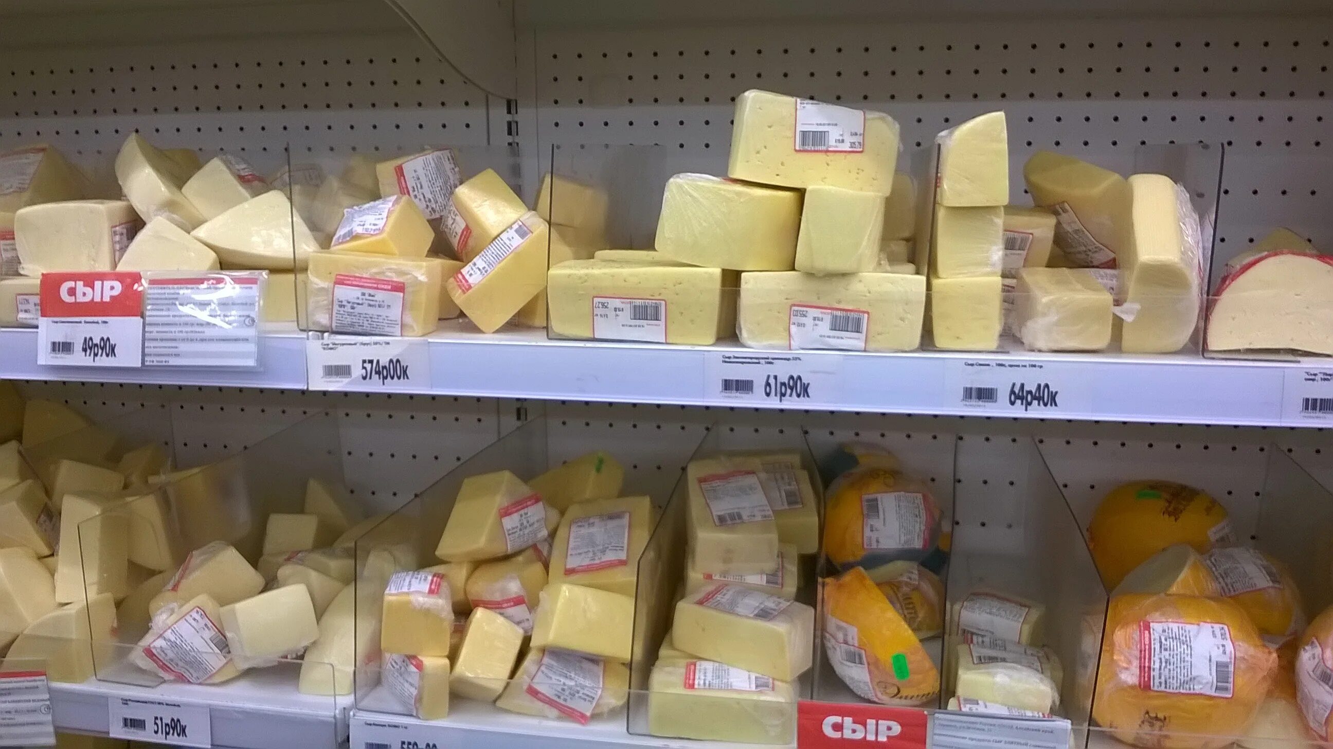 Сыр. Фермерские сыры. Выкладка сыров в магазине. Ассортимент сыров в магазине. Выкладка сыров.