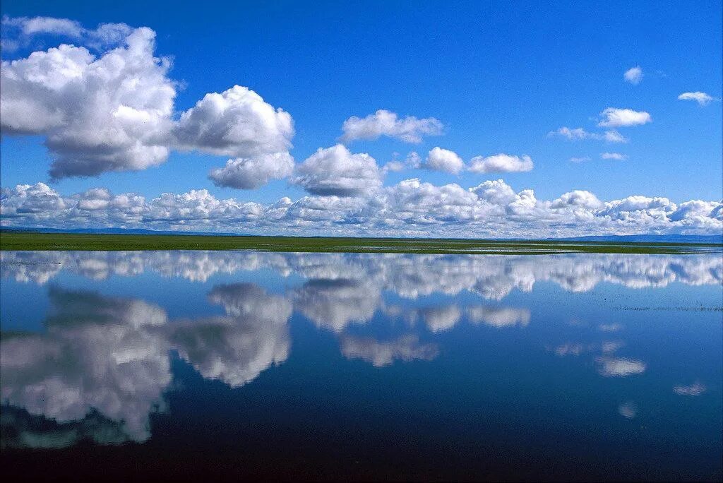 В реку смотрят облака. Отражение облаков в воде. Отражение неба в море. Река и небо. Отражение неба в воде.