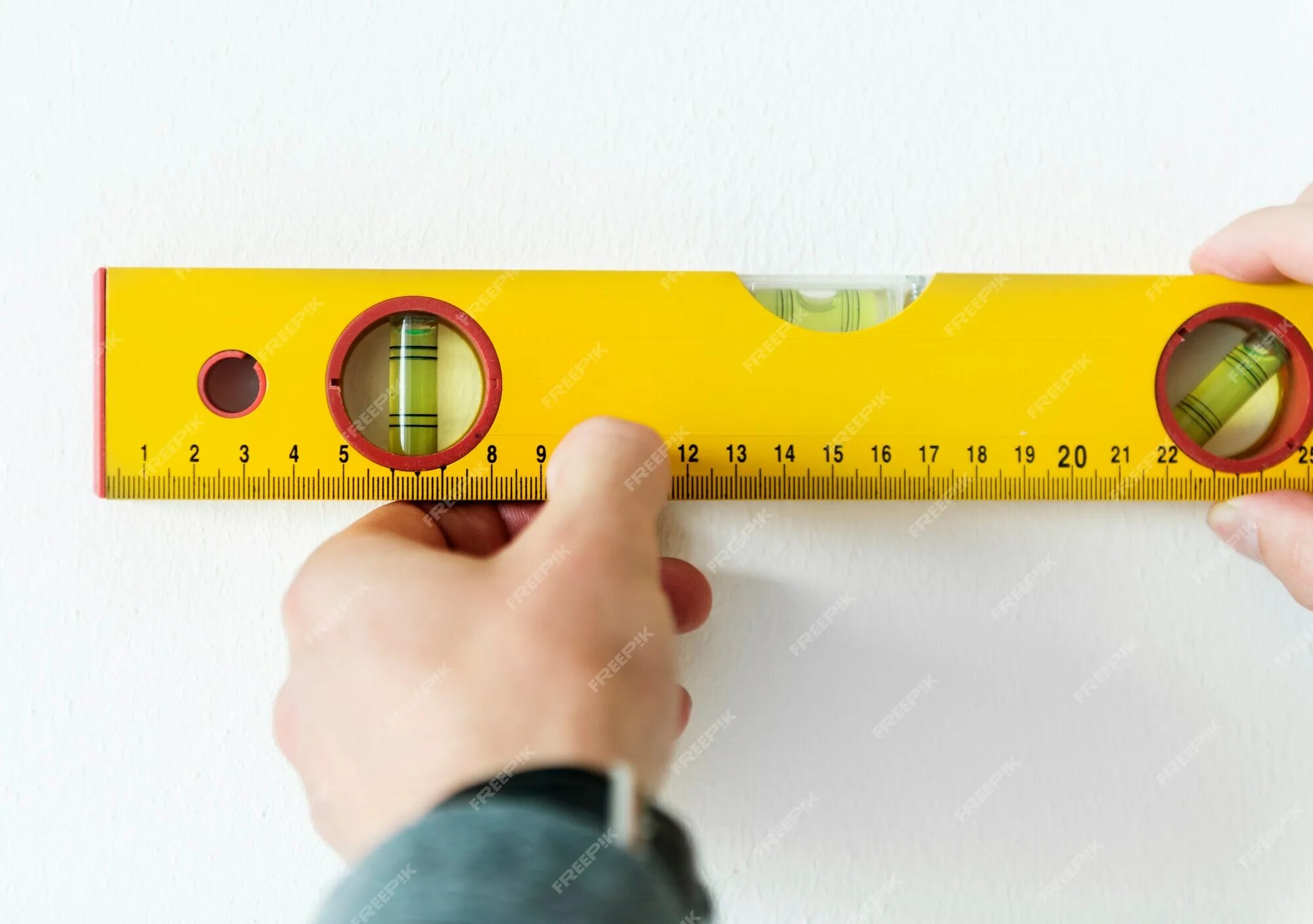 Как правильно измерить уровень. Уровень настенный. Измерение стен уровнем. Уровень метр. Измеряет метром стену.