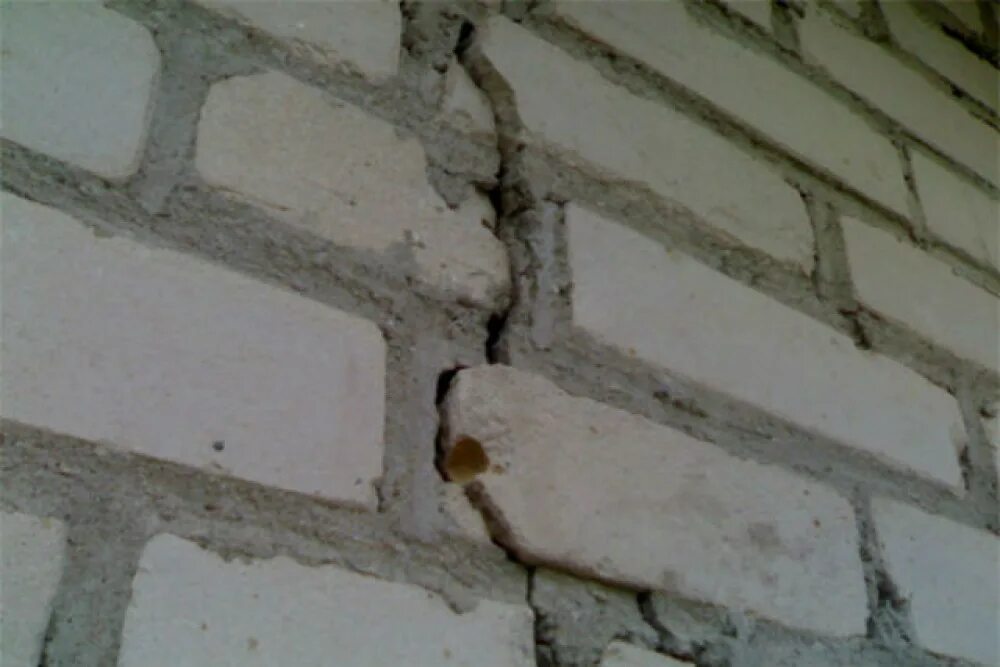 В доме появилась трещина. Трещины на фасаде. Трещина в здании. Трещина в кирпичной стене. Трещины в кирпичной кладке.