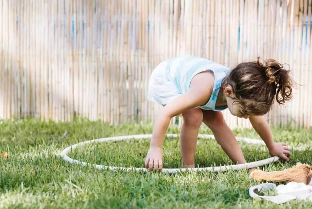 Ходить кругами по комнате. Ходить кругами. hula hoop. девочка хула на игровой площадке. дети с обручами релаксируют фото.
