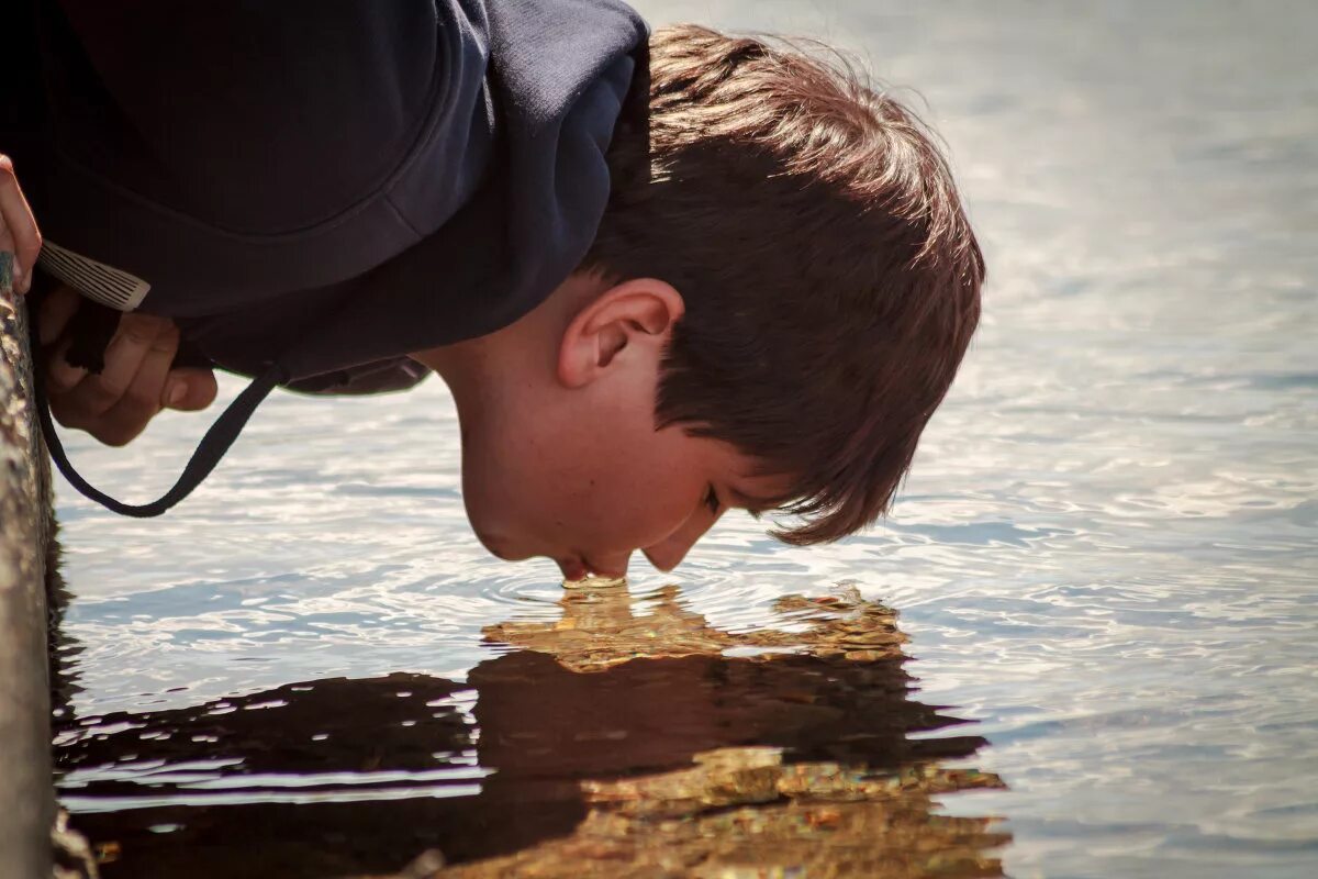 Человек пьет воду из реки. Пьет из реки. Человек пьет воду из ручья. Воду из реки ведром