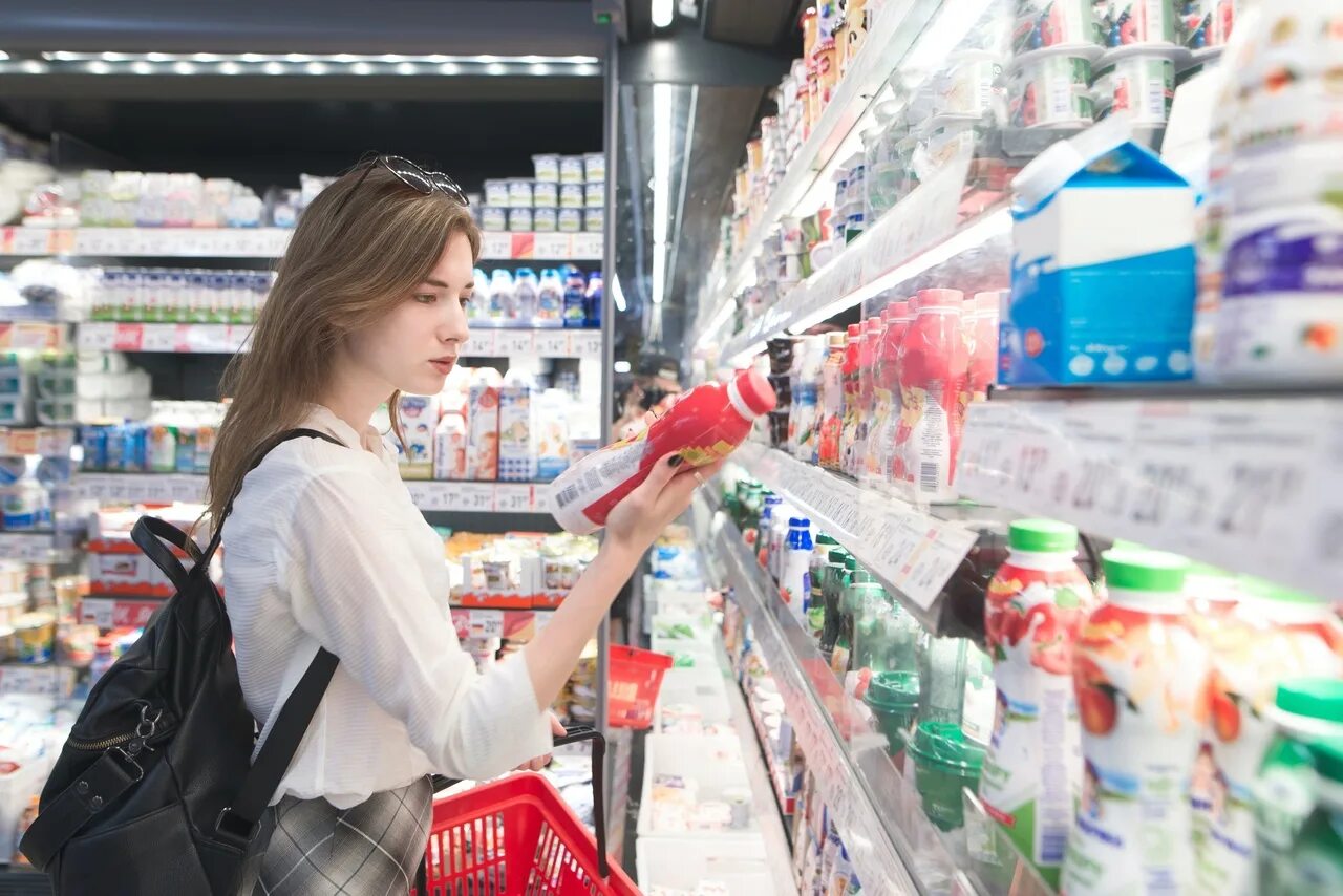 Супермаркет йогурт. Люди в супермаркете. Девушка в магазине продуктов. Купить человека. Человек прилавок