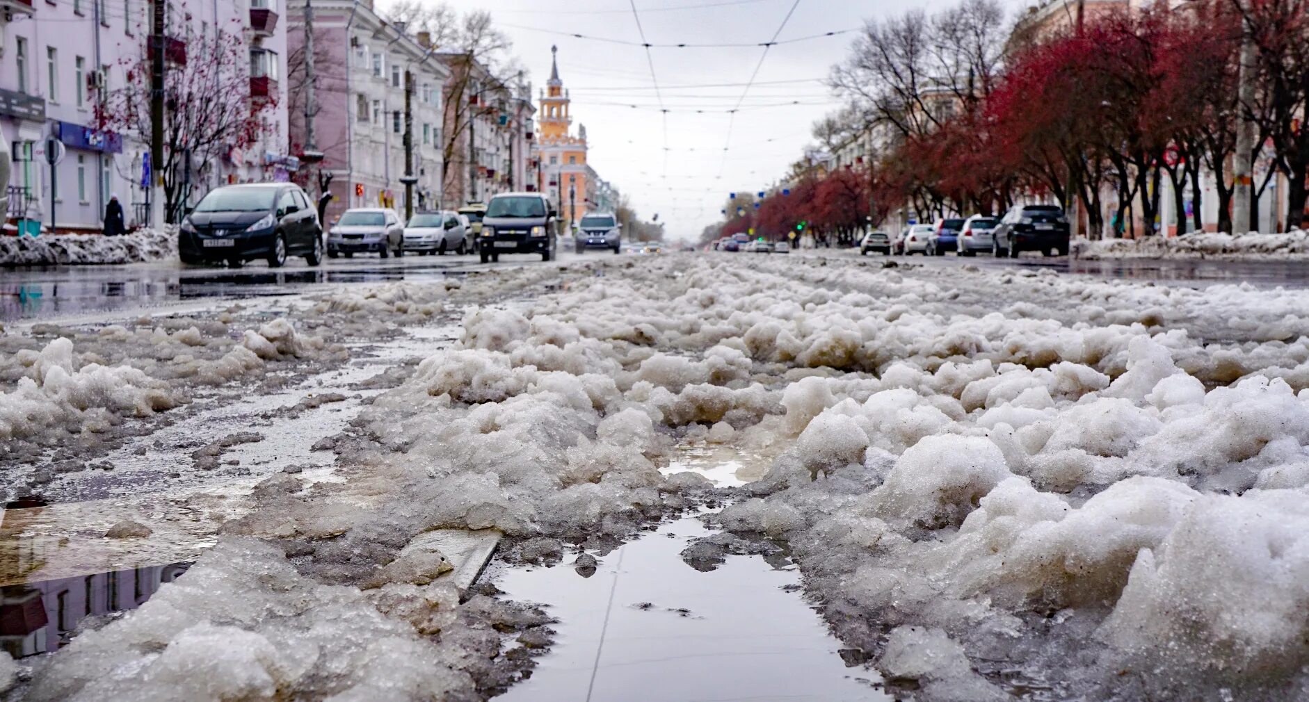 Потепление зимой. Тает снег в России. Снегопад в городе. Таяние снега в городе.