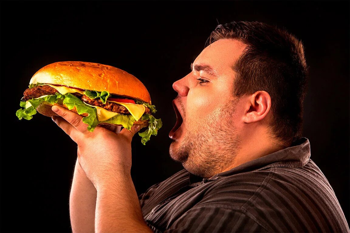 Ешь и толстым становишься. Толстый человек ест гамбургер. Человек есть большой бургер. Толстый мужчина ест бургер. Толстый человек с гамбургером.