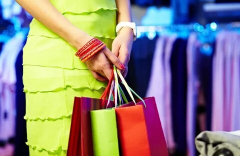 Image of shopaholic hands with three shopping bags.