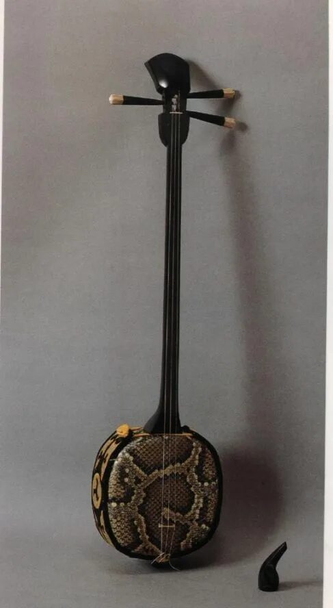 Японская трехструнная лютня с длинной шейкой. Сямисэн струнные Щипковые музыкальные инструменты. Китайский музыкальный инструмент 4 струны сэмисэн. Сямисэн струнный музыкальный инструмент. Японский струнный инструмент Сансин.