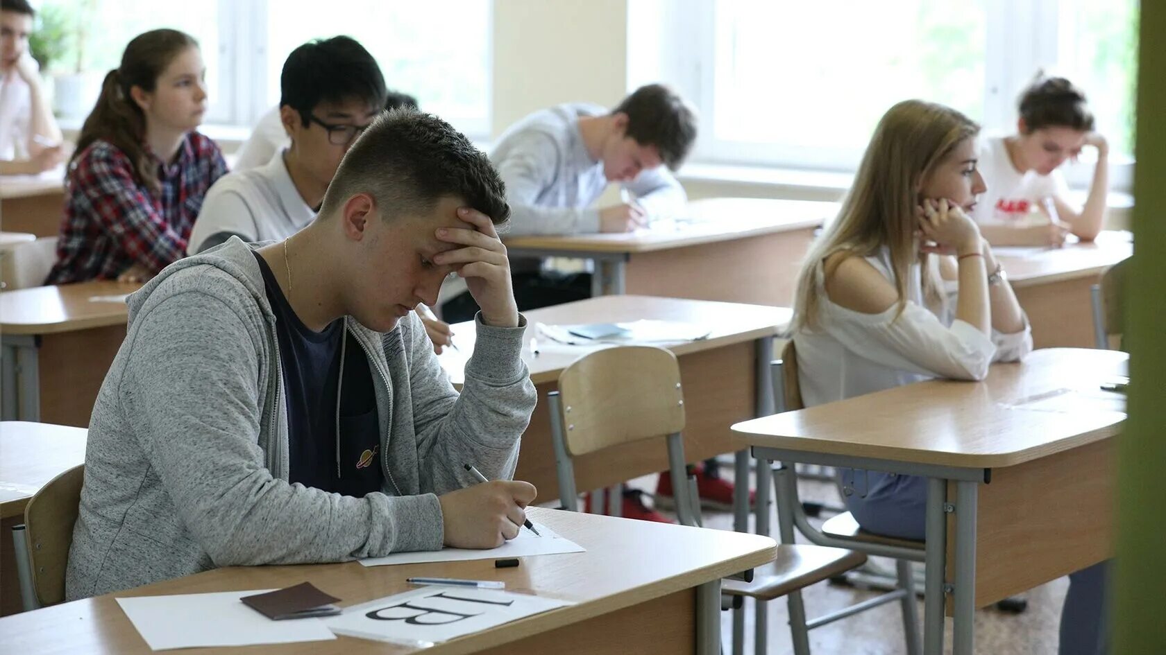 Старшеклассники за партой. Ученик на экзамене. Подросток на экзамене. Выпускной экзамен в школе. В каком вузе сдать егэ