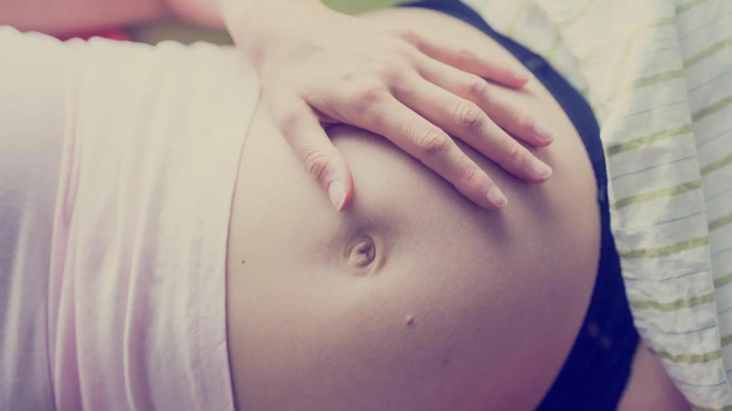 Покажите пуп. Фото беременного живота. Мужские руки на беременном животе.