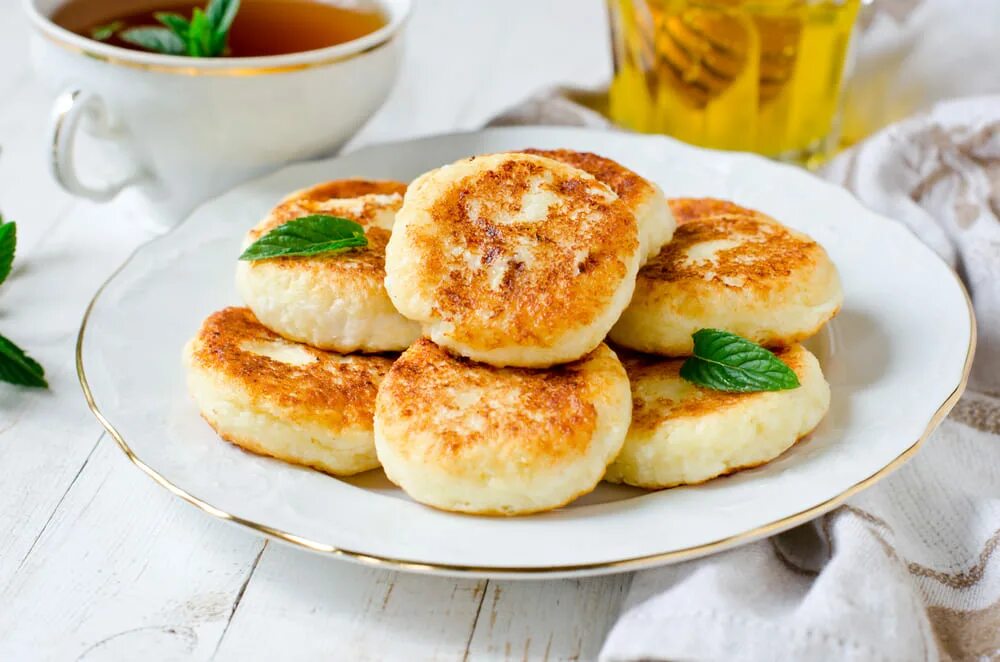 Пышные сырники фото рецепт. Сырники. Оладьи с творогом на кефире. Банановые сырники. Сырники на тарелке.