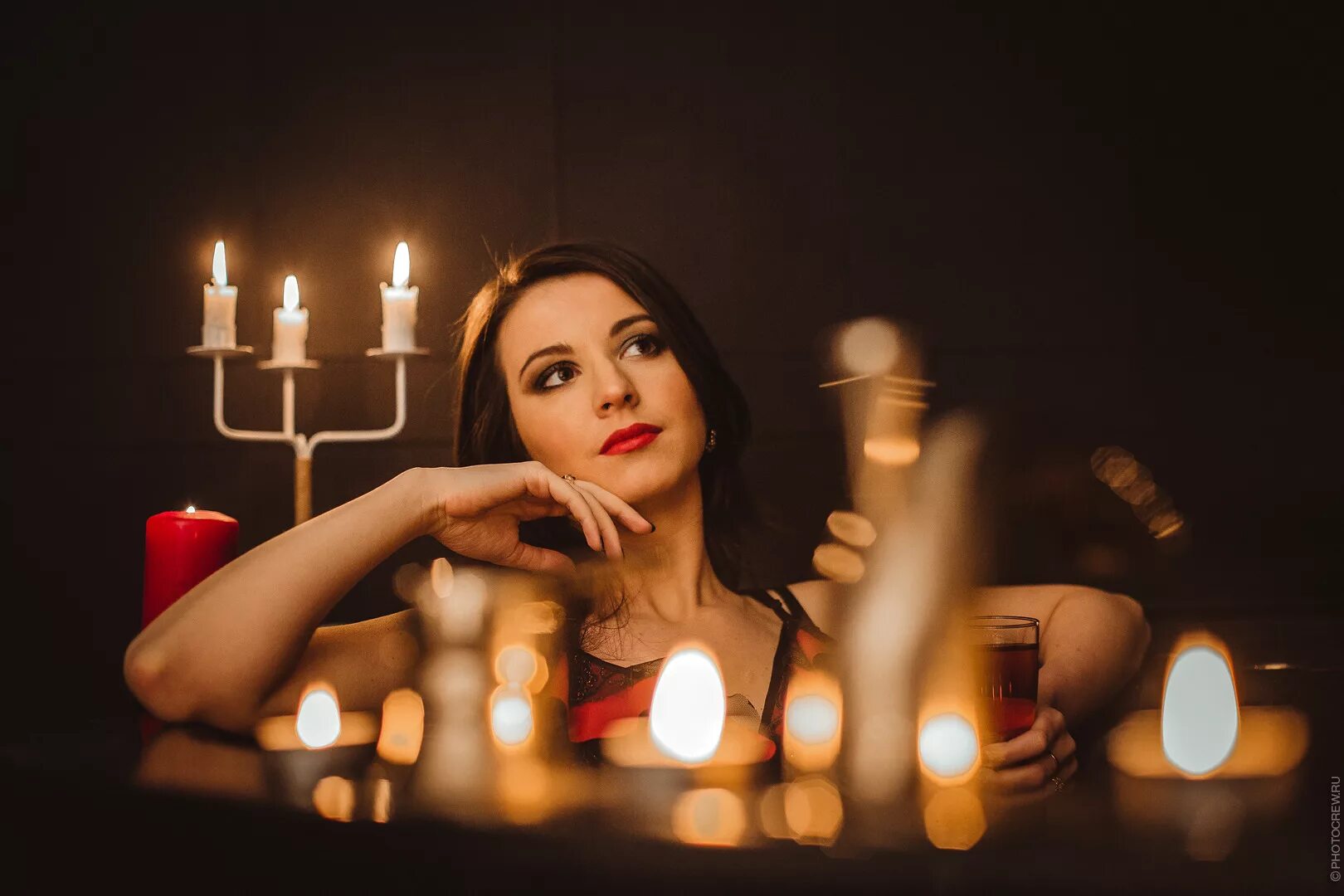 Волшебница колдует. Девушка гасит свечи. Массаж при свечах. Девушка делает свечку. Свечи как искусство.