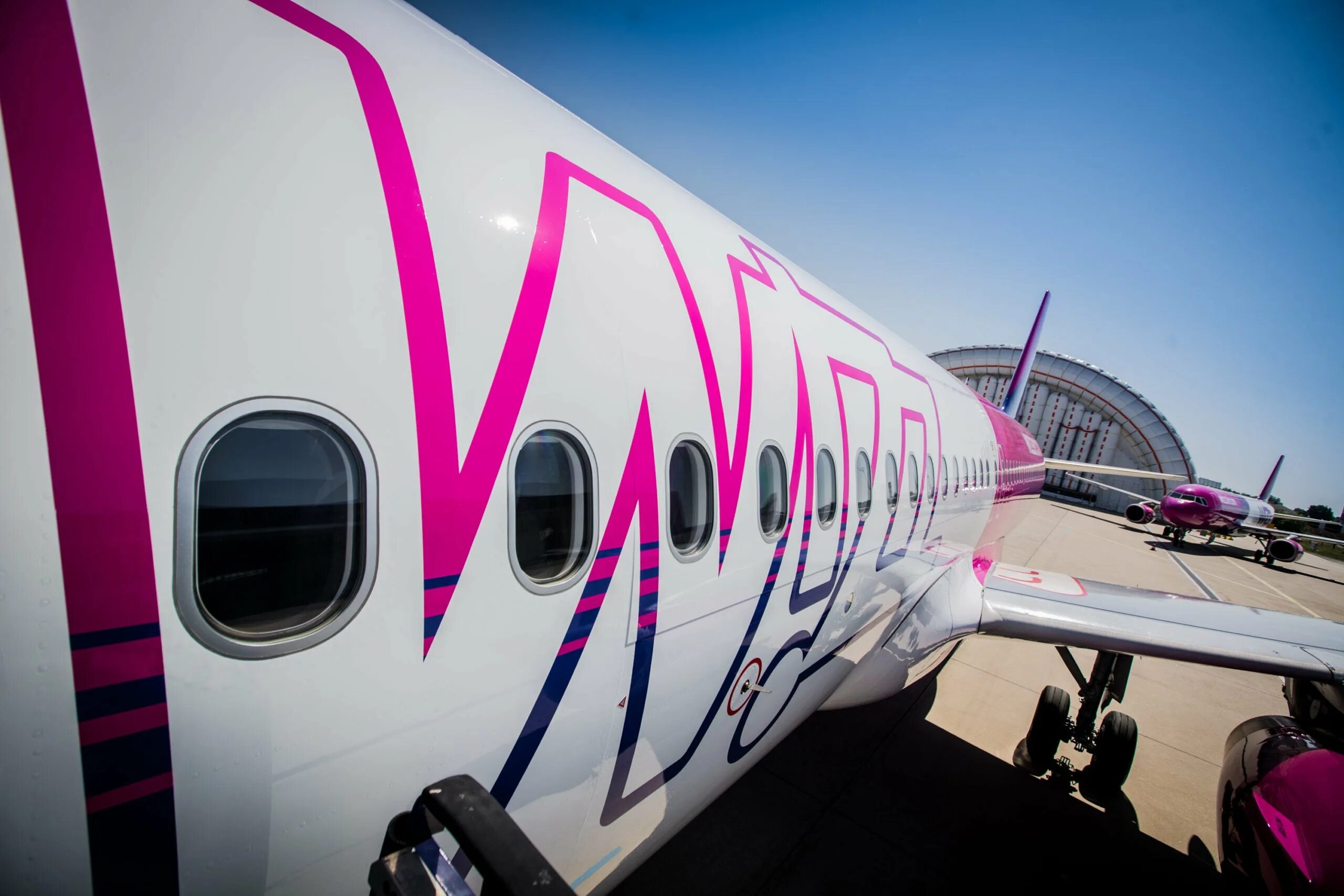 Авиакомпания wizzair. Wizz Air самолеты. Wizz Air Абу Даби. Розовый самолет. Авиакомпании лоукостеры.