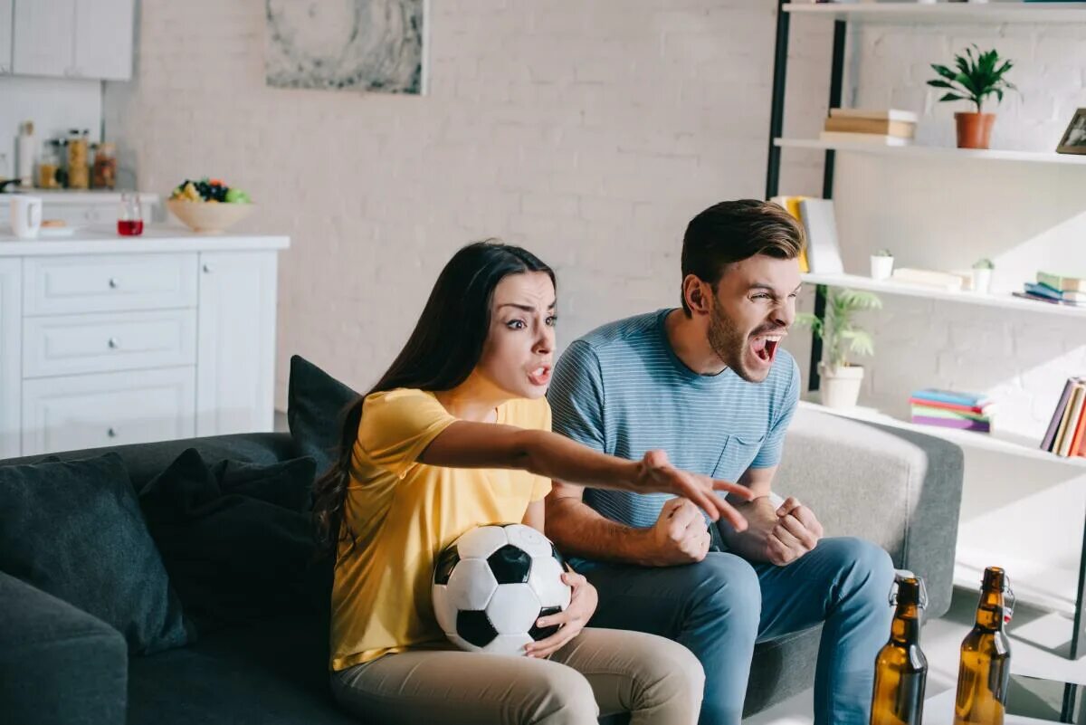 Пара смотрит футбол. Парочка смотрит футбол. Картинка пара смотрит футбол. Пара смотрит футбол по телевизору.