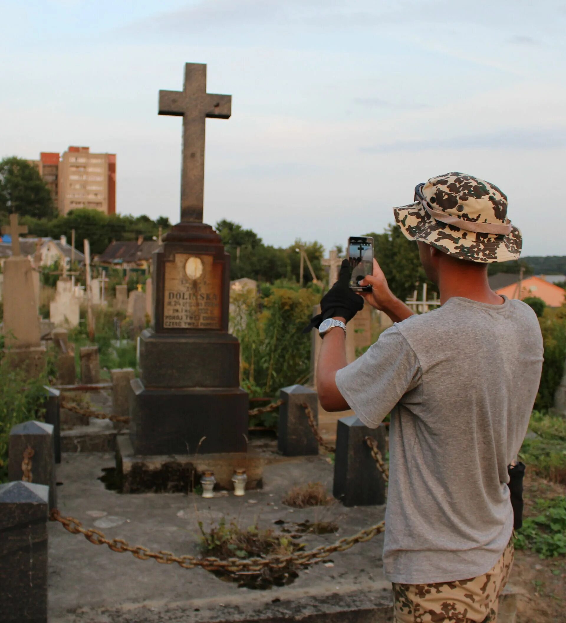 Фотографировать на кладбище. Можно фотографироваться на кладбище. Селфи на кладбище. Группа людей фотографируется рядом с могилой.