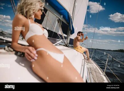 ...selective focus of woman in bikini having sunbath and her boyfriend sitt...