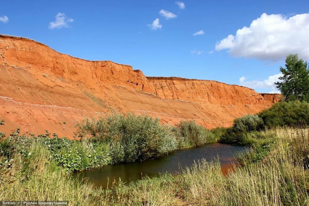 Струйчатая водная эрозия. Обрыв почвы. Склон оврага. Глина в карьере. Глиняный овраг или глинистый.