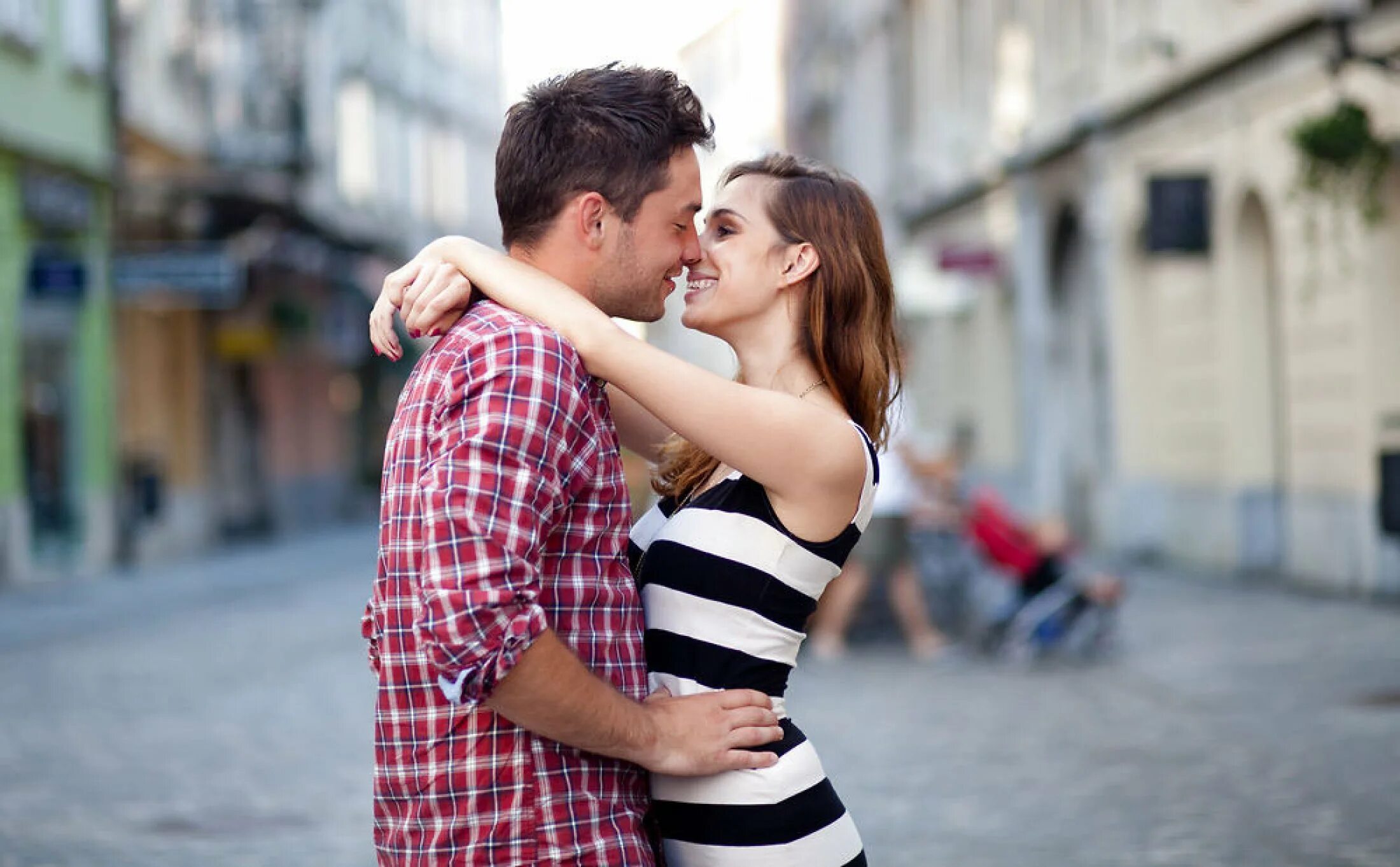 Пара обнимается на улице. Молодая пара. Поцелуй на улице. Страстный поцелуй на улице.