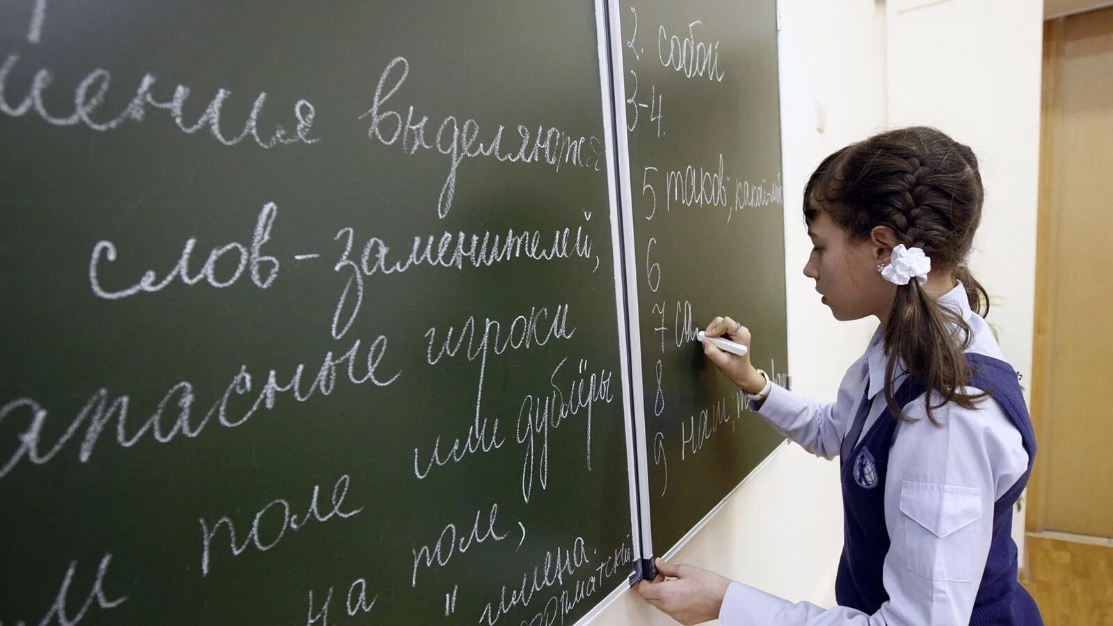 Изучение русского языка в москве. Урок руксскогоя зыка в школе. Ученик пишет на доске. Доска. Ребенок пишет на доске.