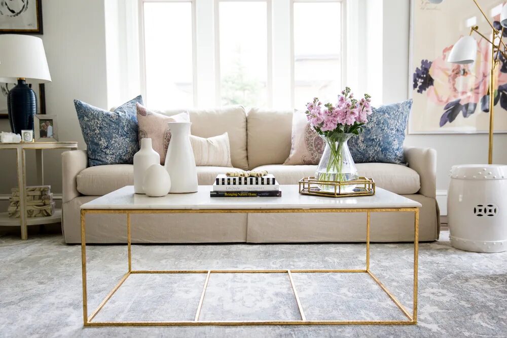 The lamp is on the coffee table. Living room table. coffee table. living room with table picture. table in the room.