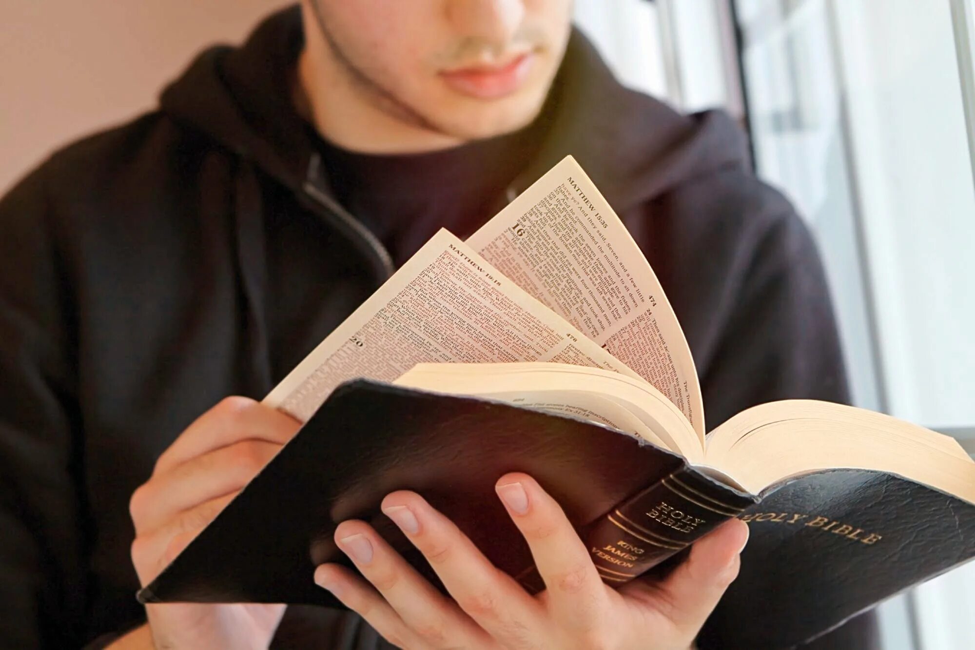 Человек с Библией. Человек читает Библию. Мужчина с Библией. Парень с книгой в руках. Читая учебники ребята