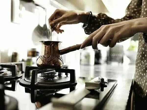 Barista steaming milk at the coffee machine in a cafe - people, leisure - Stock 