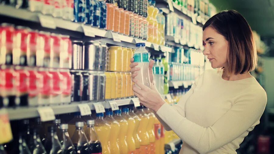 Свежевыжатый сок в бутылке. Прилавок с продуктами. Выбираем сок в магазине. Напитки в магазине. Сок в магазине.