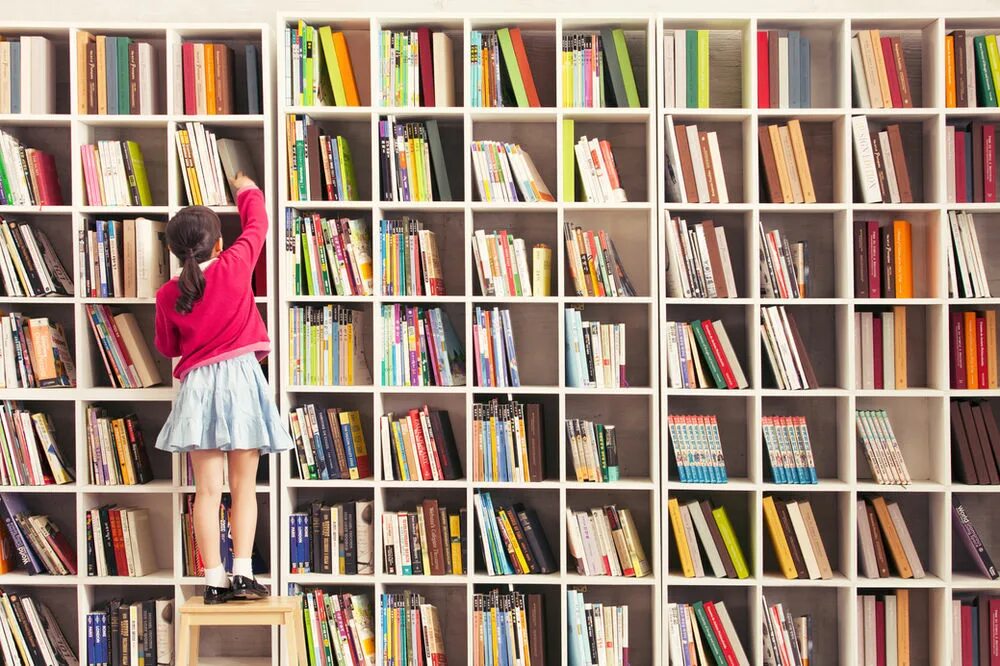 Книжная полка в магазине. Library Shelves Top view. Girl finding book. Girl reaching for book on Shelf.