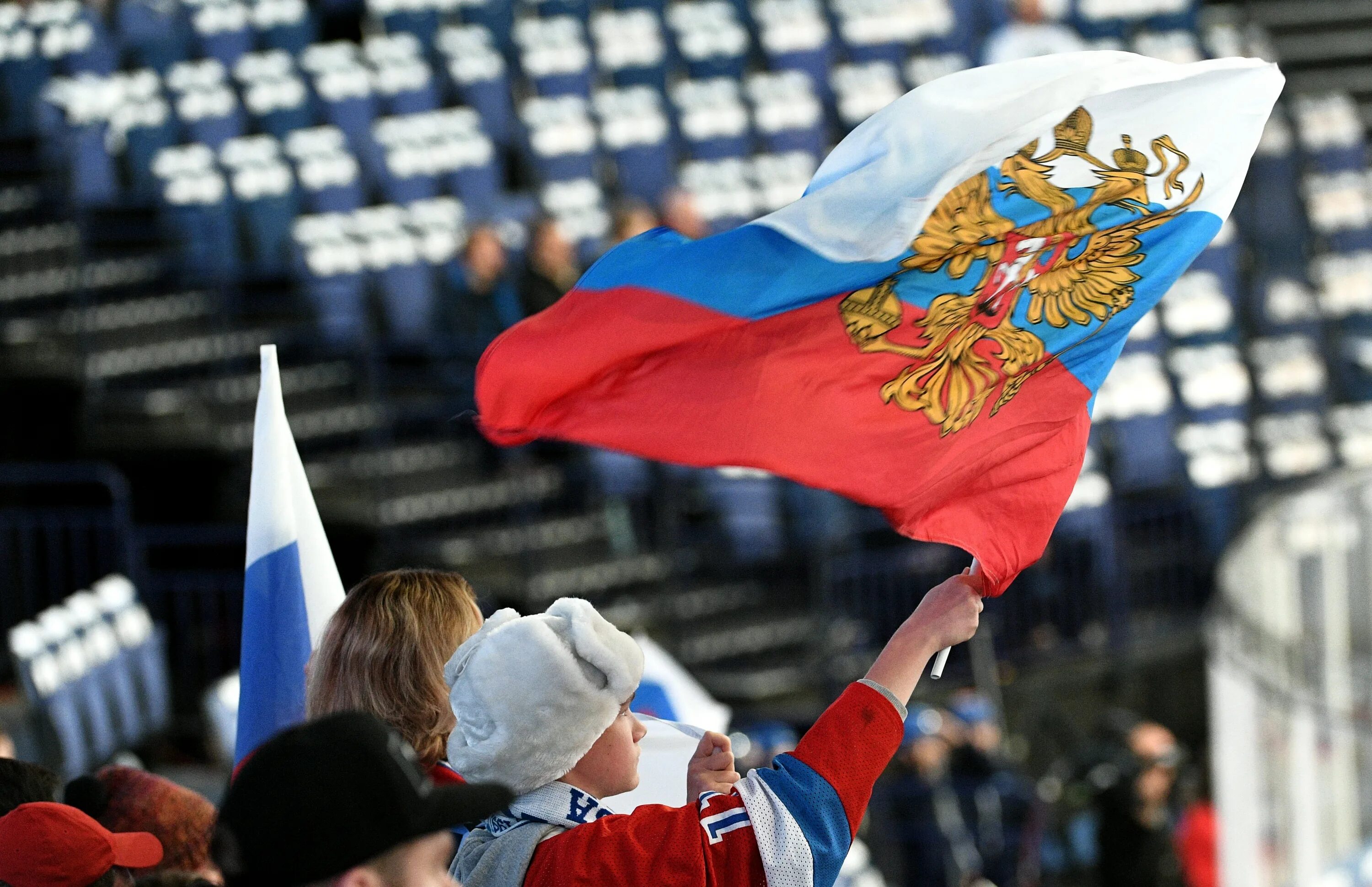 Спортсмен с флагом. Российский флаг на трибунах. Спортивный флаг России. Достижения российского спорта. Какие группы поддерживают россию