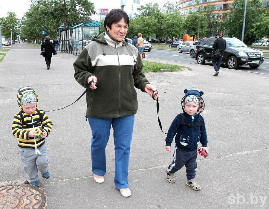 Мама ведет квадробера. Выгуливает ребенка на поводке. Мама студента. Мама и школьник. Мама с дочкой идут.