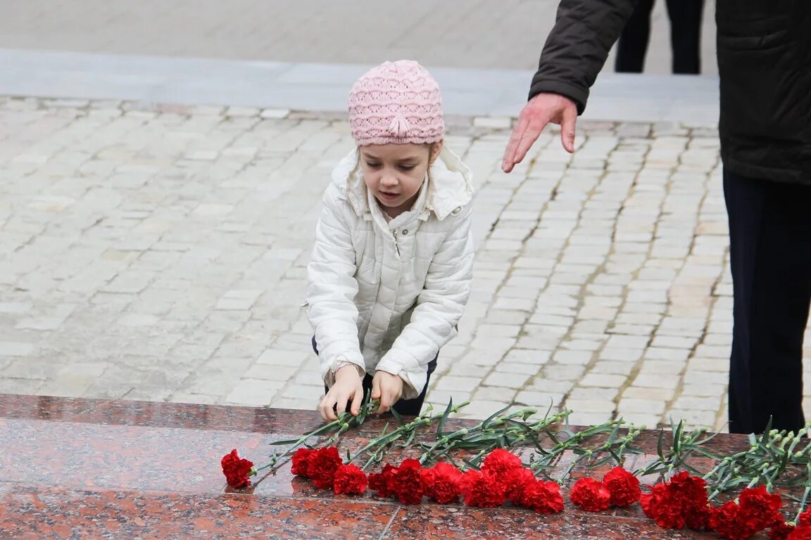 Люди возлагают цветы