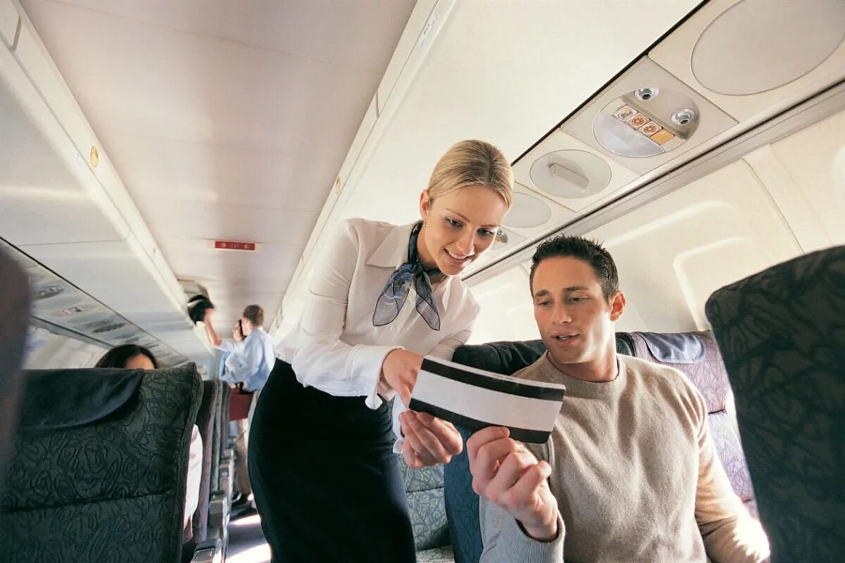 The plane showed the passengers. Стюардесса и пассажир. Бортпроводник в самолете. Пассажирские перевозки самолет. Бортпроводник с пассажирами.