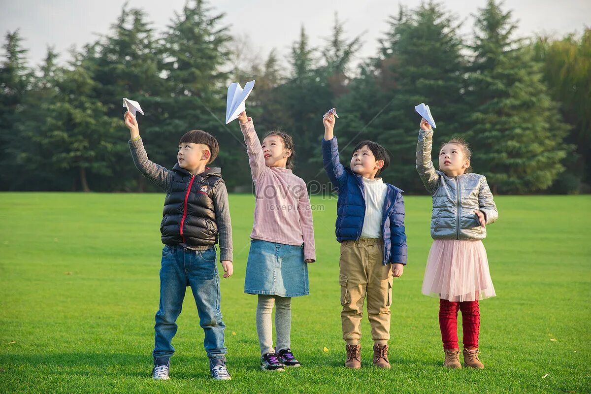 Children Play on the grass. Parents and children on the grass. The children were playing on the grass. Playing paper