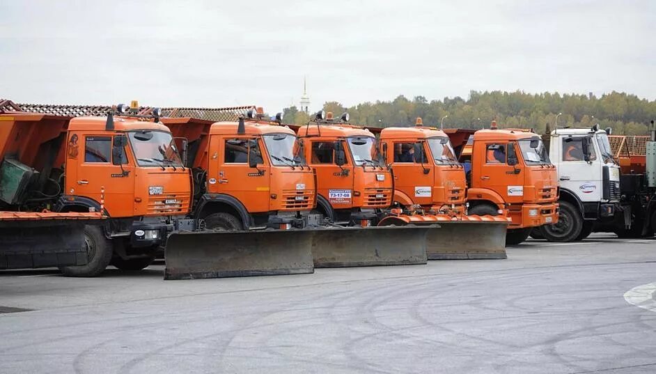 Дорожные работы зимой. Стоянка уборочной техники. Подготовка дорог к зимнему периоду. Рабочие на дороге. Трактор для чистки дорог.