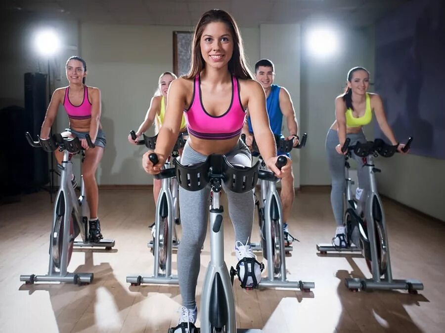 Сайклинг тренировка. Сайкл (cycle) зал. сайкл аэробика. девушка на велотренажере. тренировка на велотренажере сайклинг.